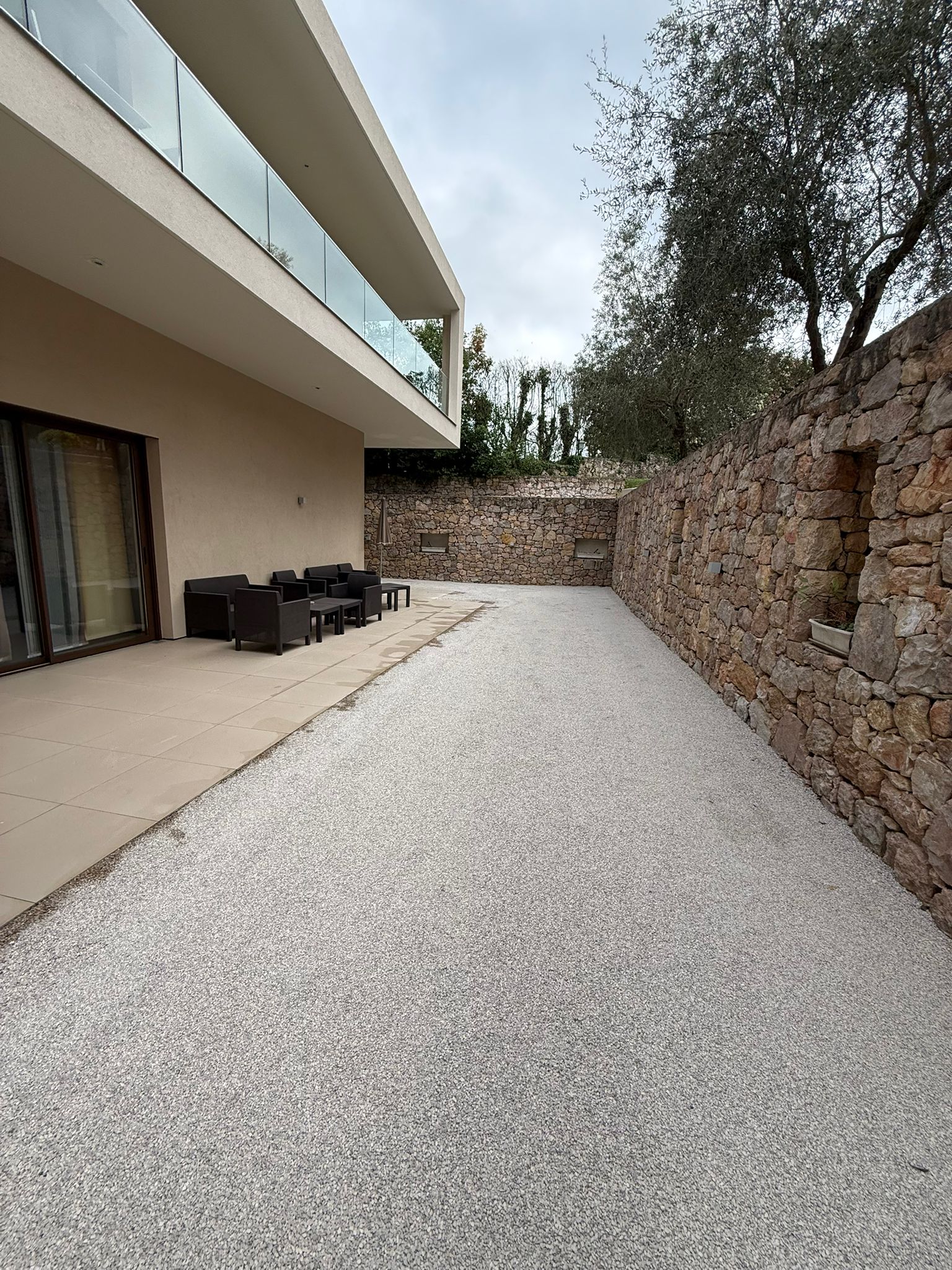 Bicouche gravillonné beige terrasse villa contemporaine mur pierre