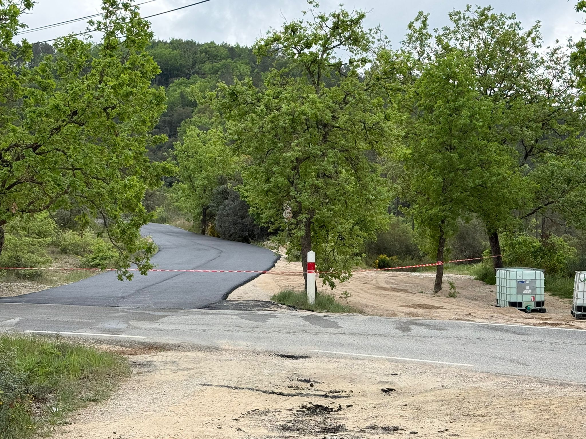 Voie d'accès forestière en enrobé noir avec raccord route départementale